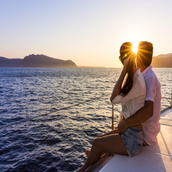 pareja-puestadesol-velero-en-mar